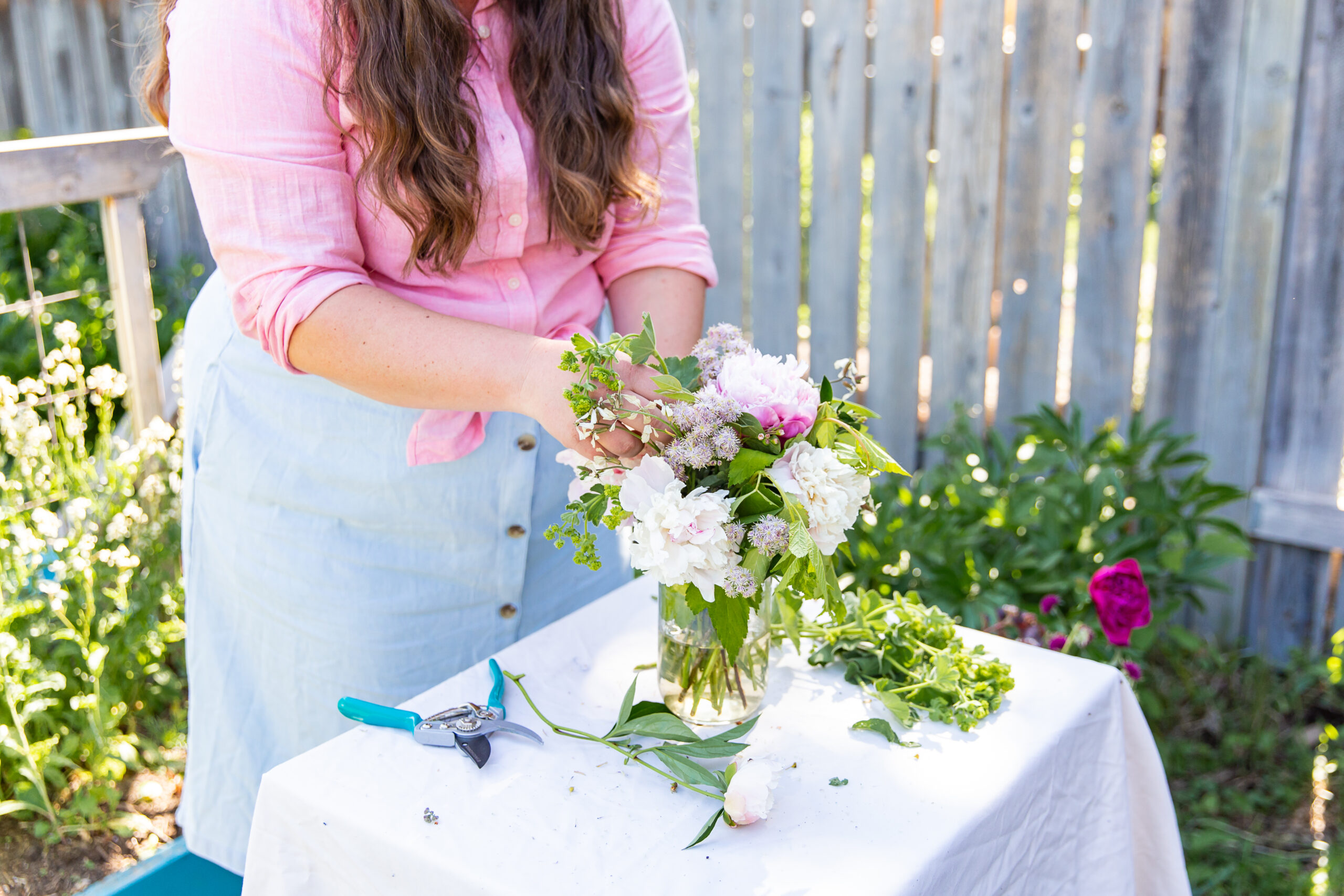 woman making a peony bouquet